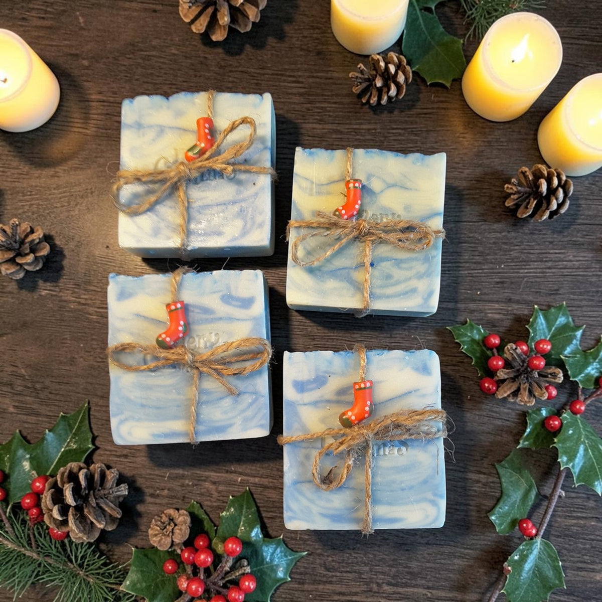 snowdrift christmas soap on a wooden surface with pine cones and pine needles with a candle in the background