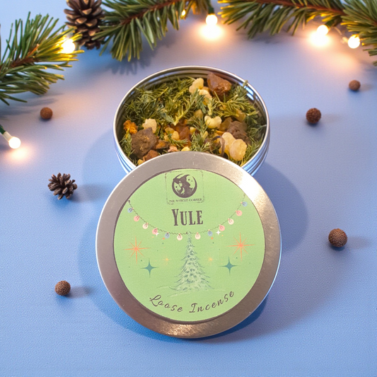Yule loose incense in a tin with decorative elements on a blue background