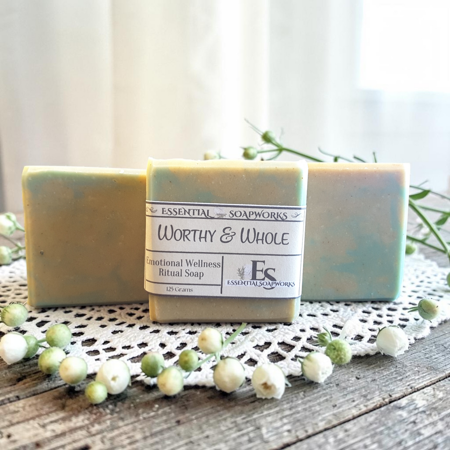 Worthy & Whole Emotional Wellness Soap on a wooden surface with decorative elements.