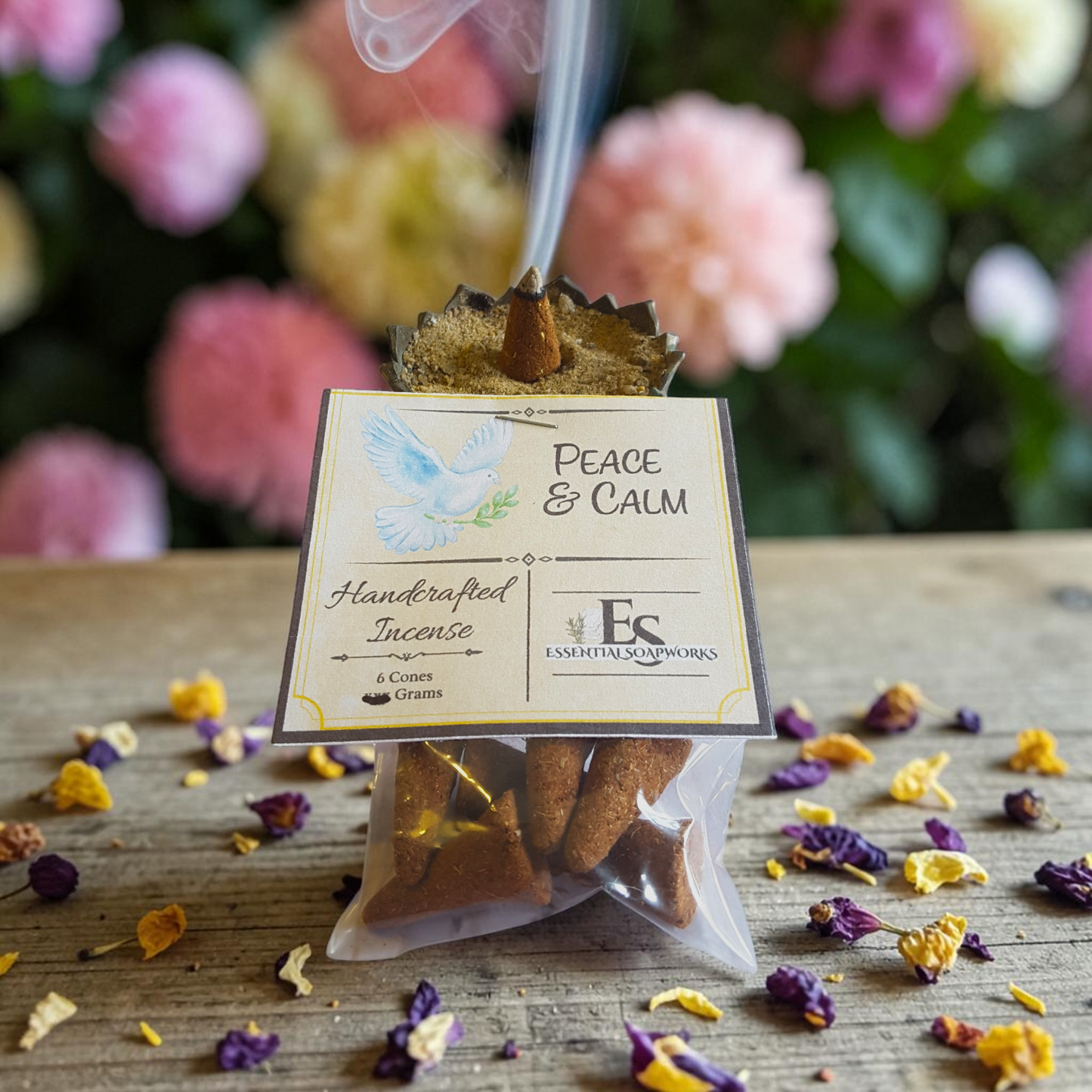 handmade peace and calm incense on a wooden surface with flowers in the background