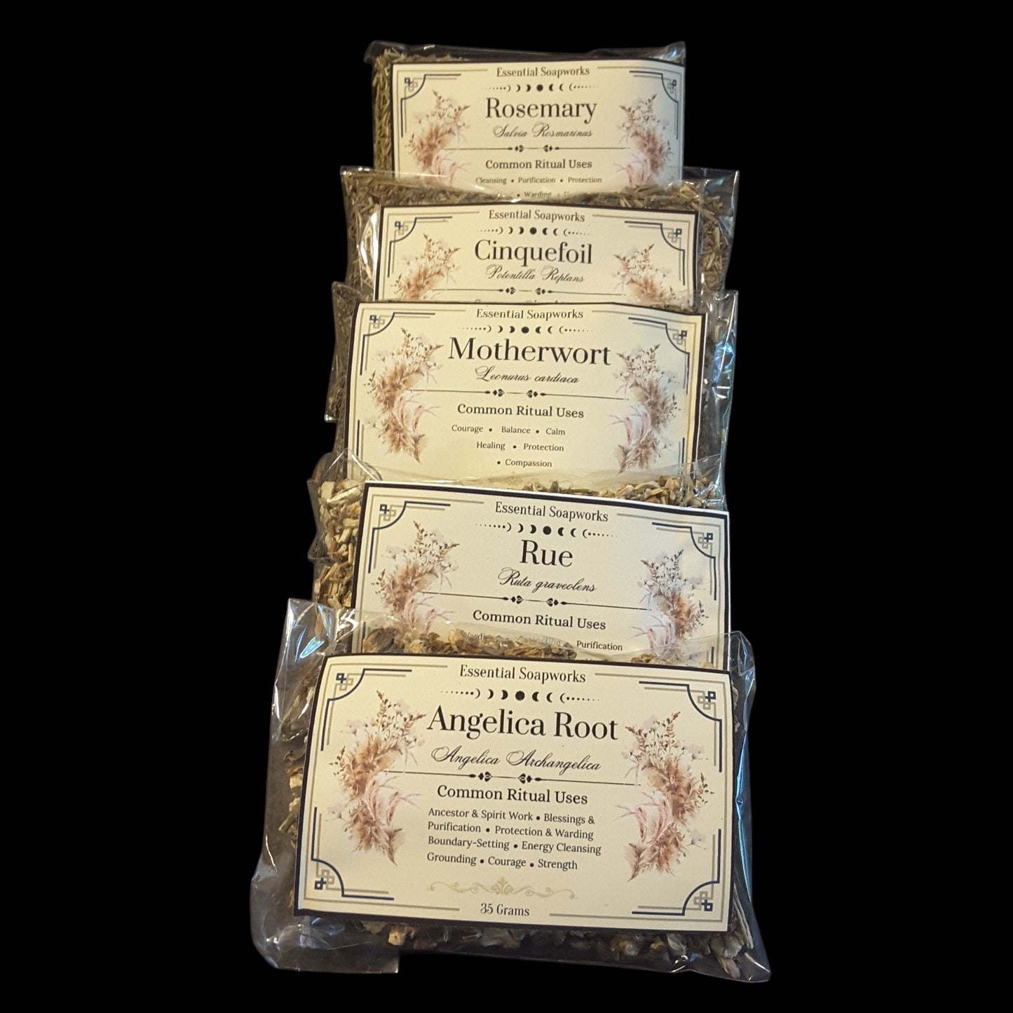 Five clear plastic bags of dried botanical blends stacked vertically against a solid black background. The labels read Rosemary, Cinquefoil, Motherwort, Rue, and Angelica Root, with decorative beige labels and visible dried herbs inside.