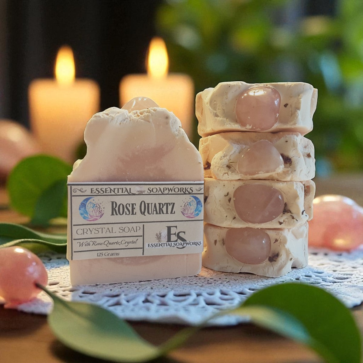 Rose Quartz crystal soap with packaging on a decorative surface with candles and greenery.