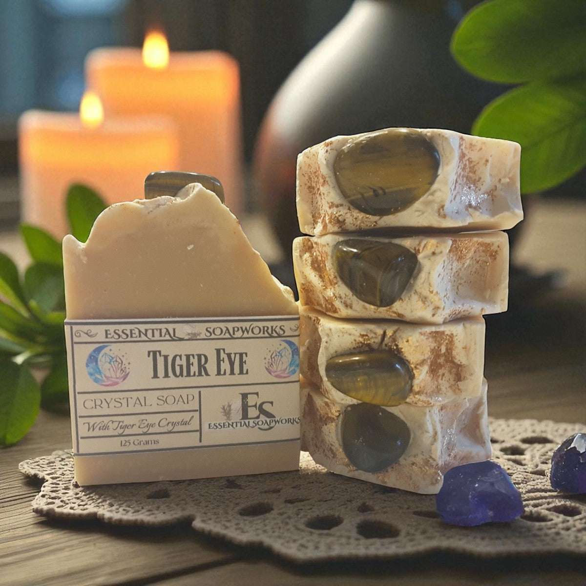 Tiger Eye crystal soap on a wooden surface with candles and plants in the background