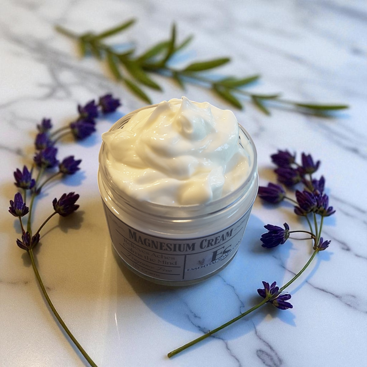Jar of magnesium cream with lavender flowers on a marble surface