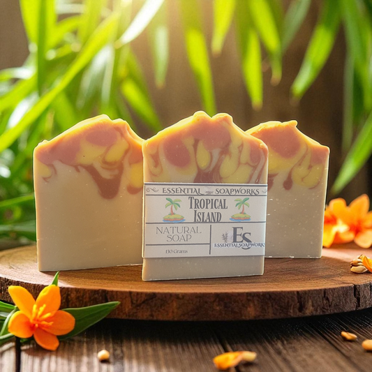 Three bars of soap with a label on a wooden surface with plants in the background