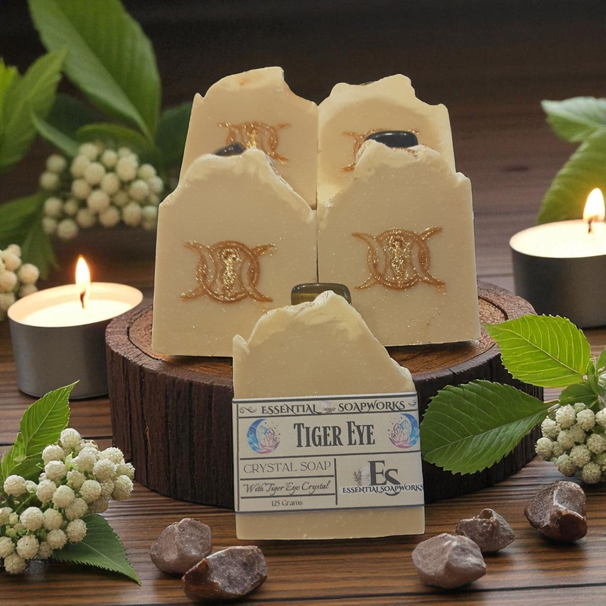 Tiger Eye Crystal Soap with branding on a wooden stand surrounded by candles and stones.
