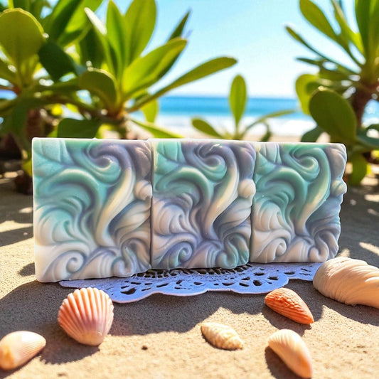 wave-patterned soap bar on sand with seashells and plants in the background