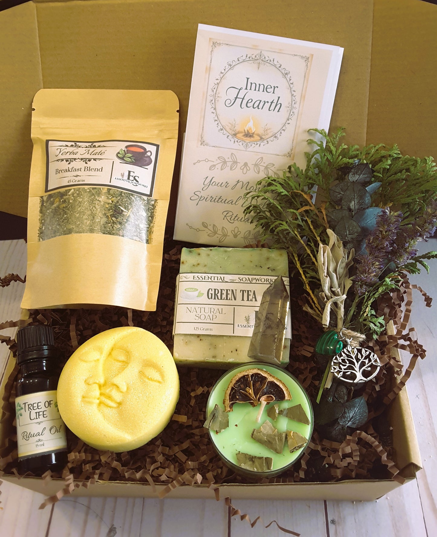 Spiritual Wellness Ritual kit including soap, tea, and a smoke cleansing bundle on a wooden surface.