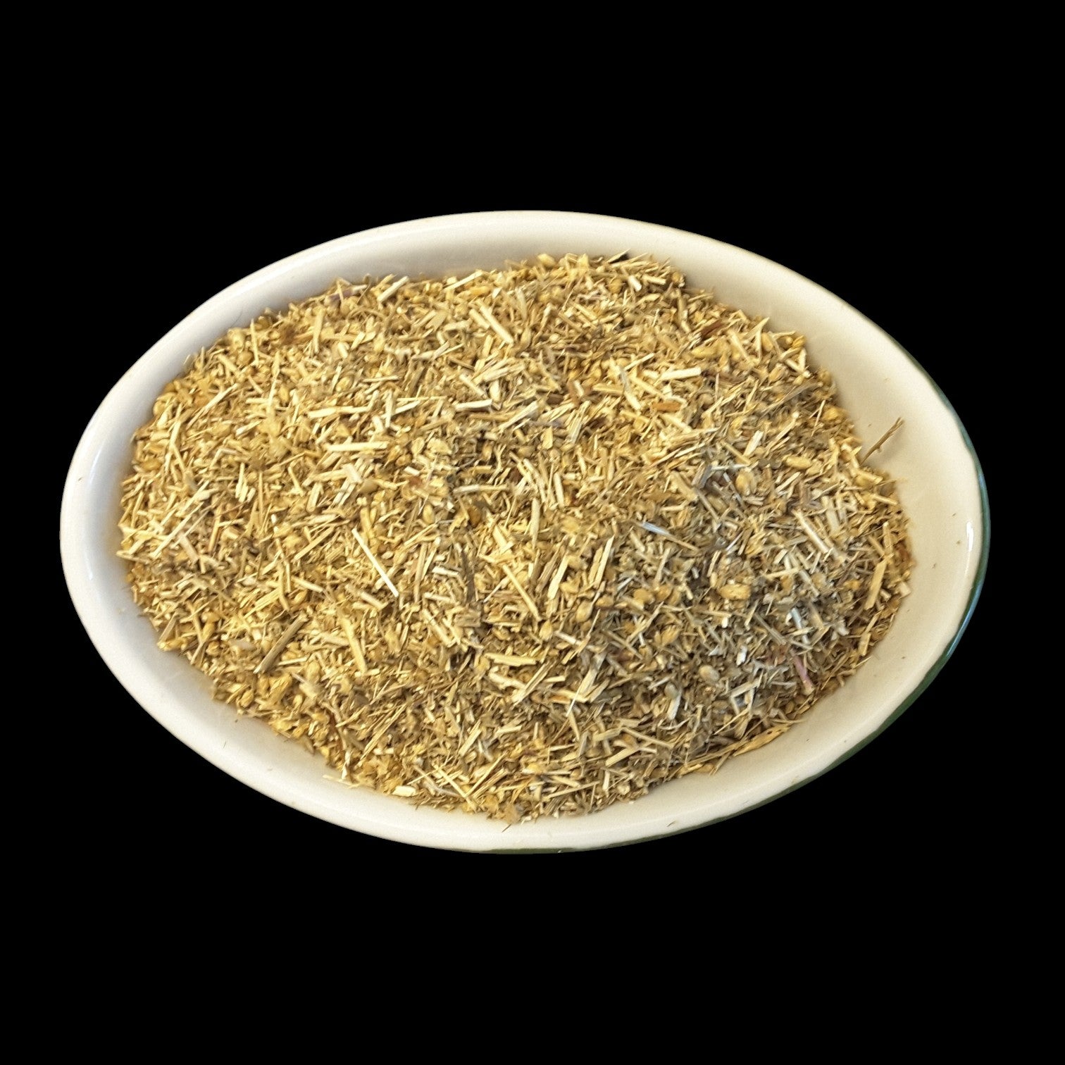 A white oval bowl filled with yarrow herb for witchcraft shown against a solid black background.