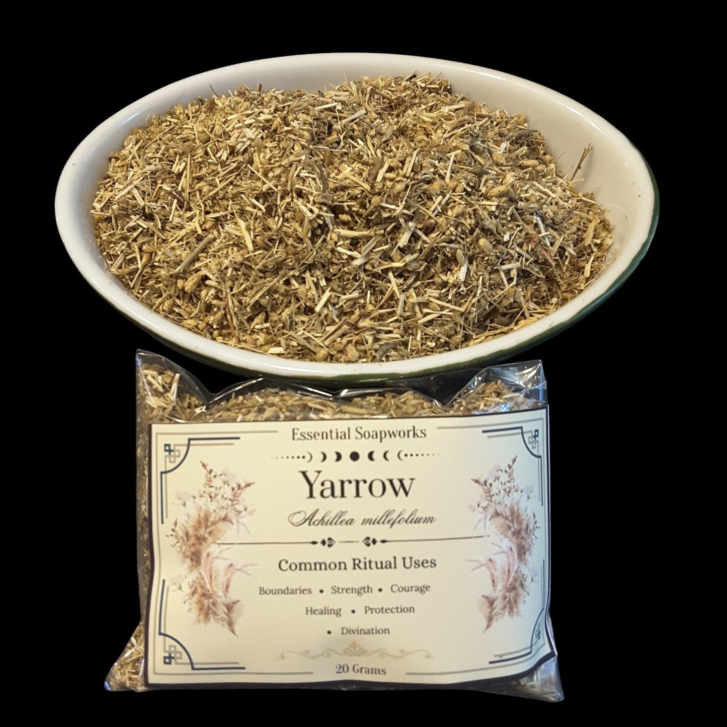 A bowl filled with dried yarrow herb above a clear plastic bag of Essential Soapworks Yarrow, showing the product and its packaging on a black background.