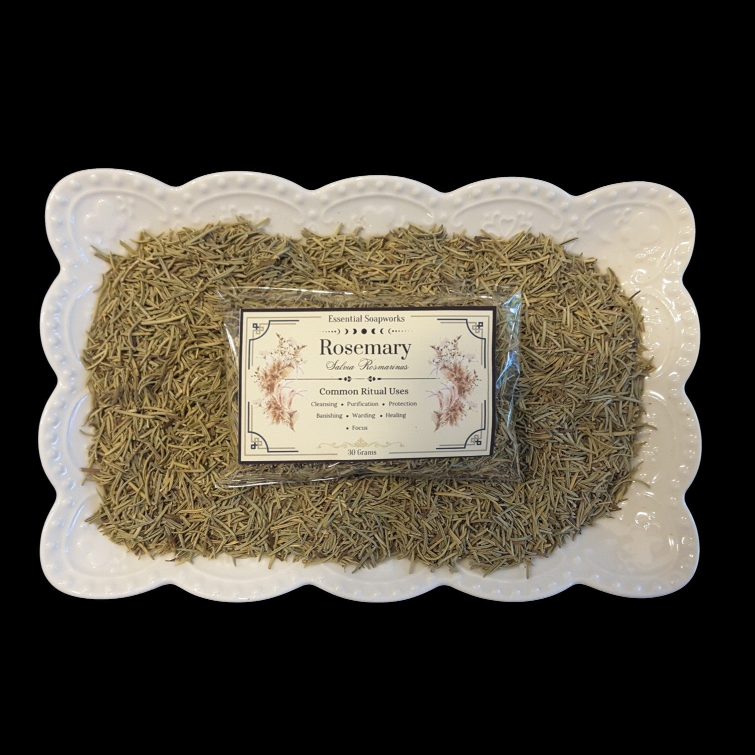 a package of dried rosemary on a bed of rosemary in a white dish on a black background