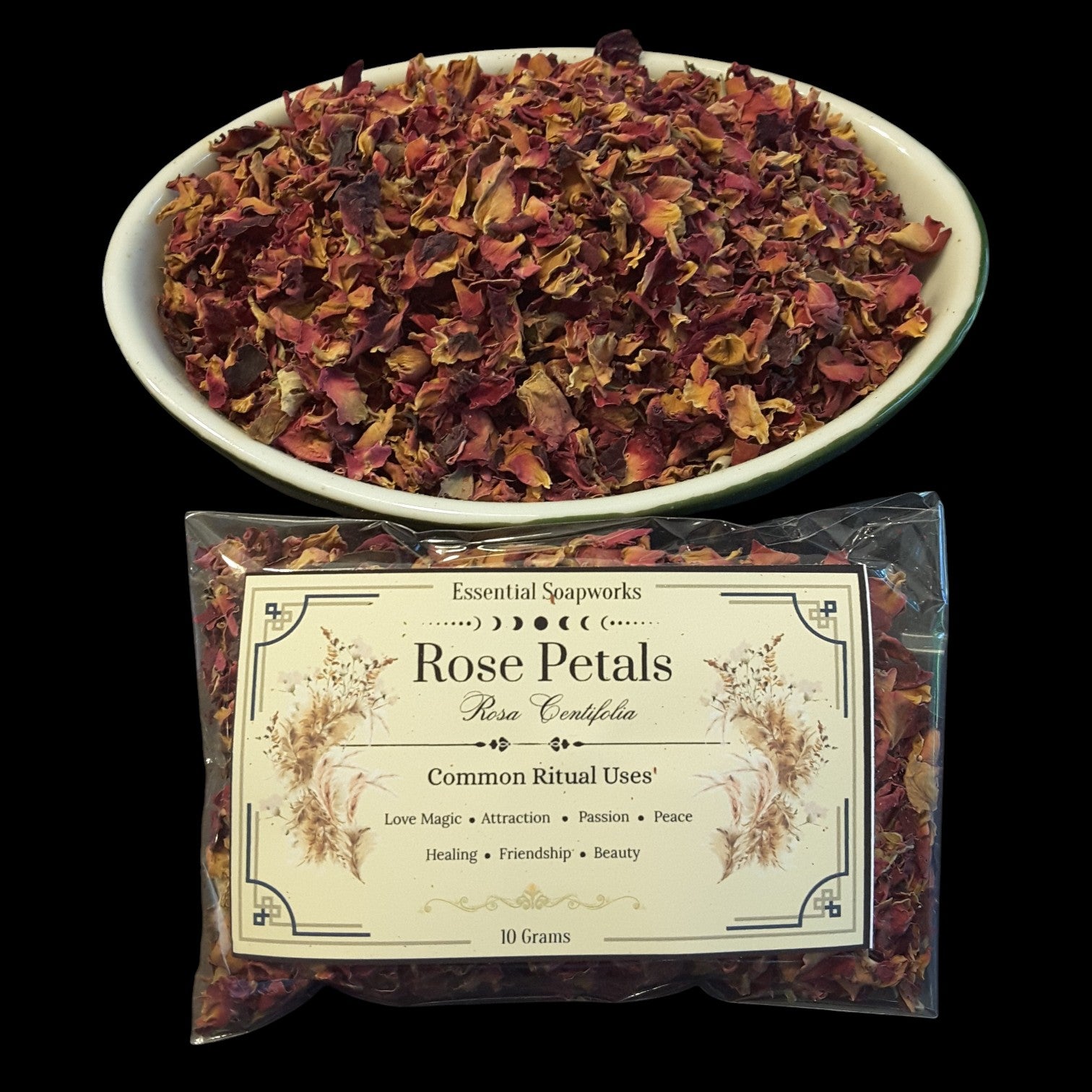 A bowl filled with dried rose petals above a clear plastic bag of rose petals with a cream label reading 'Essential Soapworks Rose Petals' on a black background.