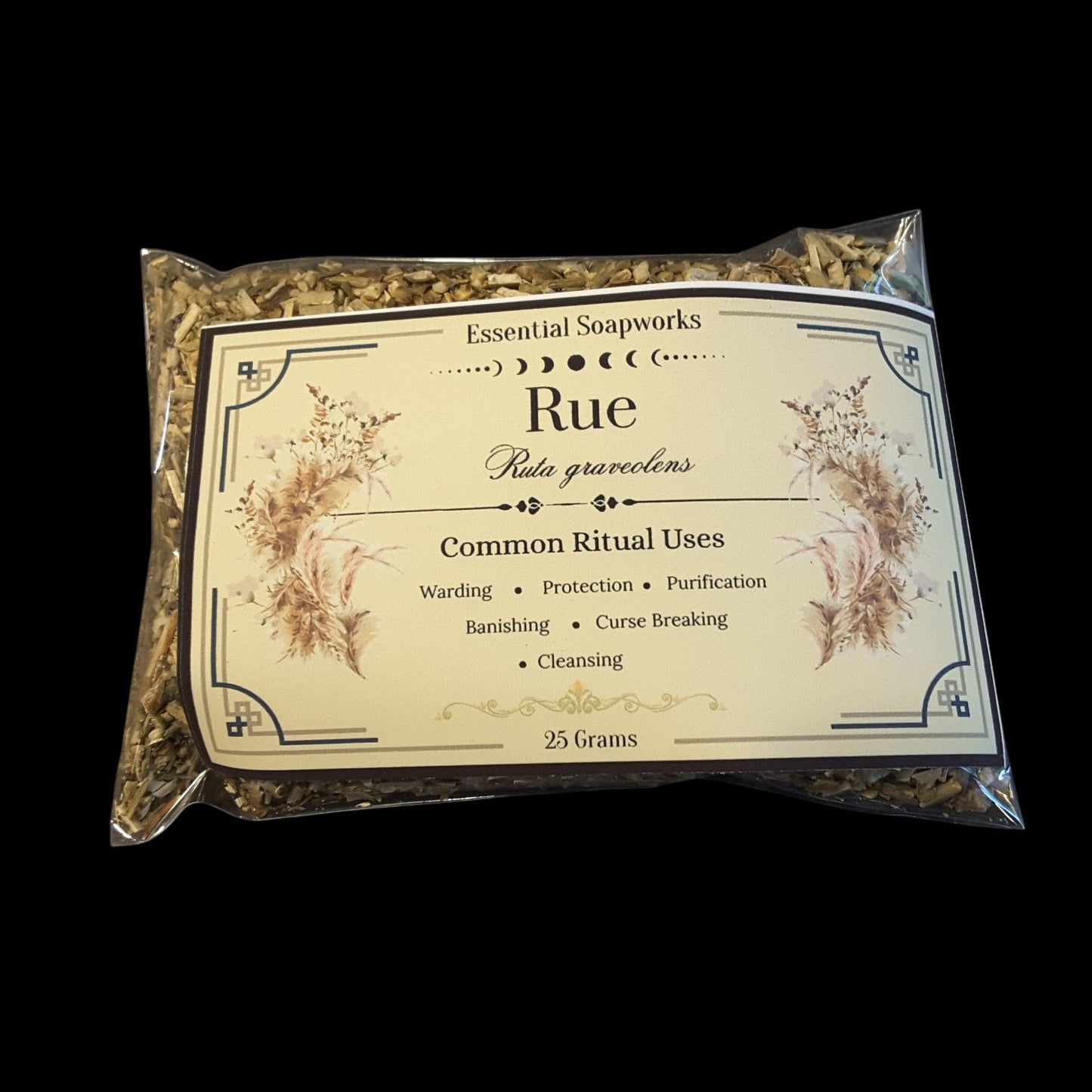 A clear plastic bag of Essential Soapworks Rue herb for witchcraft showing the dried green and brown rue herb inside with a cream-colored label detailing its common ritual uses.