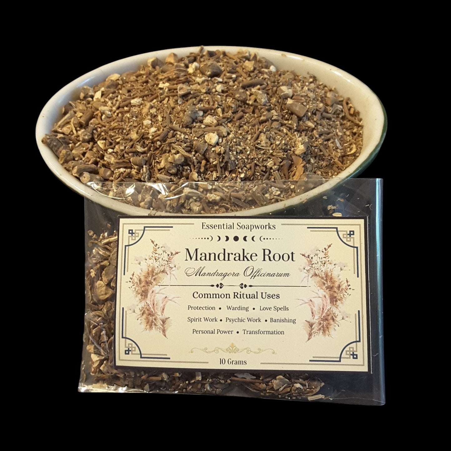 Mandrake Root shown in a clear bowl filled with dried roots, with a clear packet of 10 grams in front displaying a cream label that reads 'Essential Soapworks Mandrake Root'.