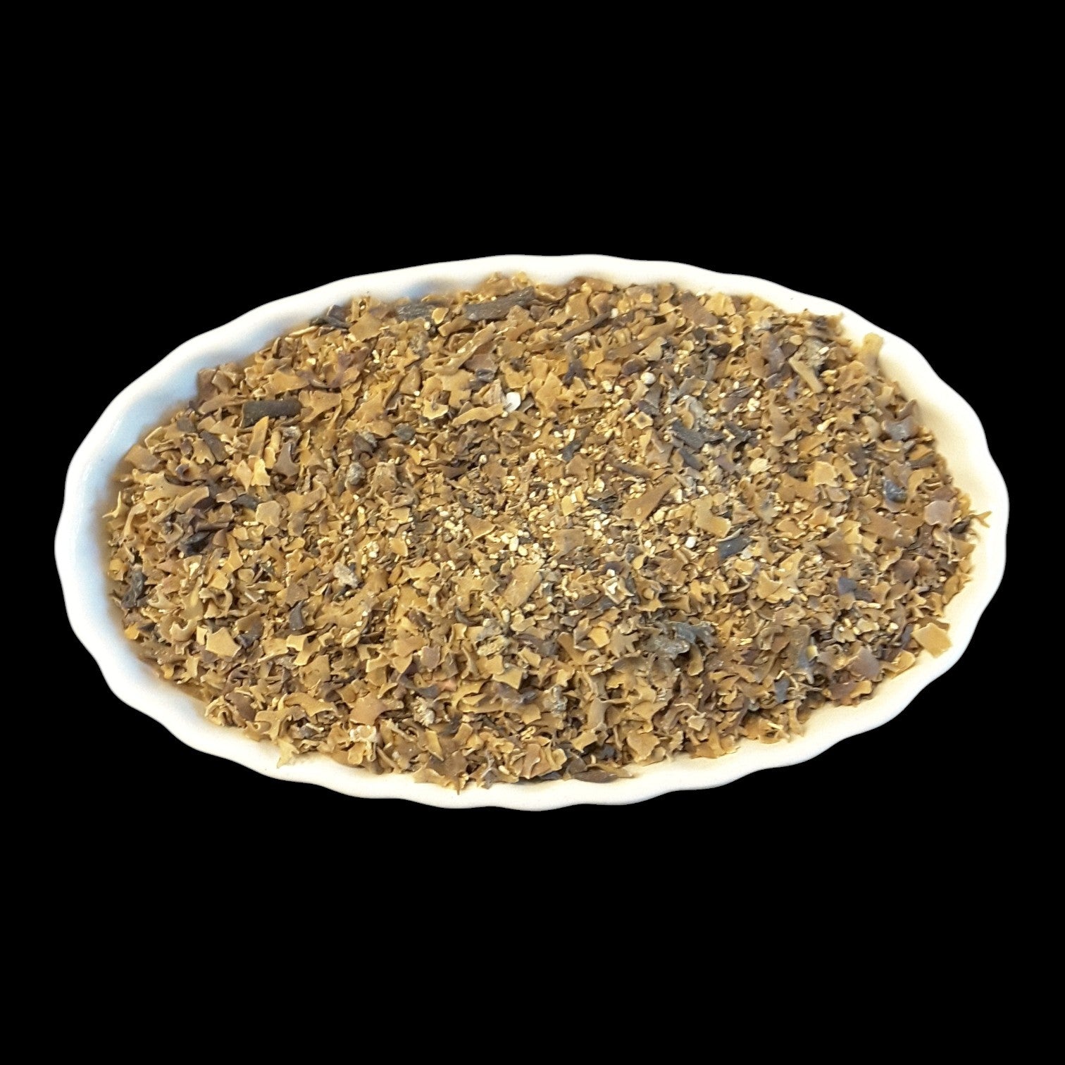 A white scalloped oval dish filled with irish moss, photographed against a solid black background.