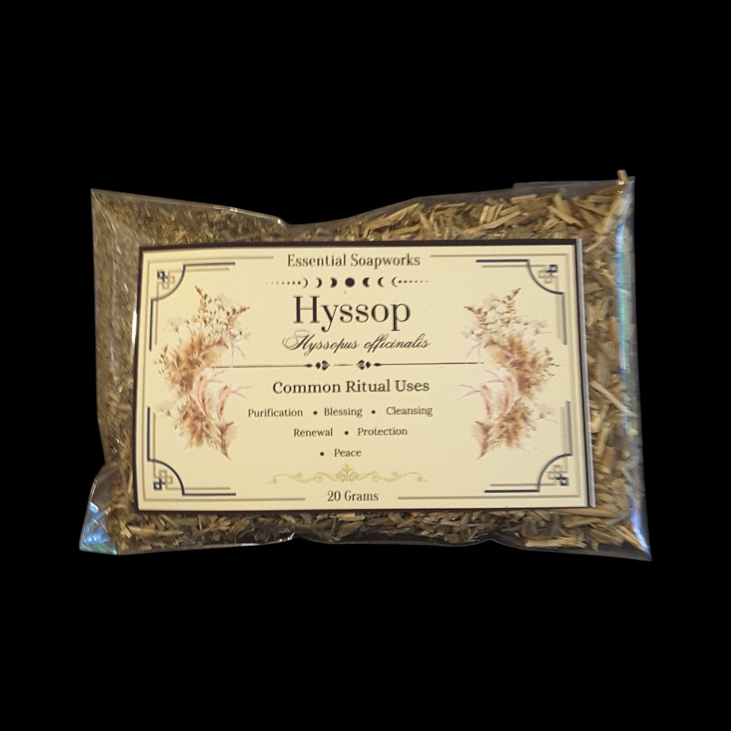 A 20g clear plastic bag of Hyssop dried herbs by Essential Soapworks, featuring a cream-colored label with botanical illustrations, set against a solid black background.