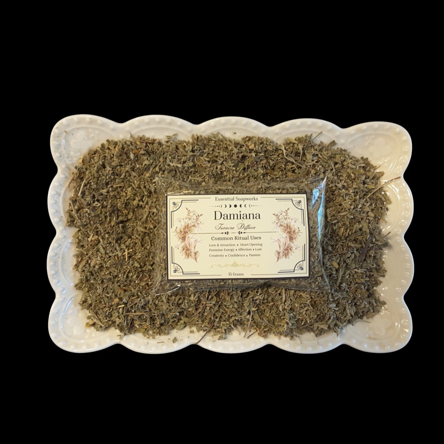 A package of Damiana displayed on a white scalloped ceramic dish against a solid black background.