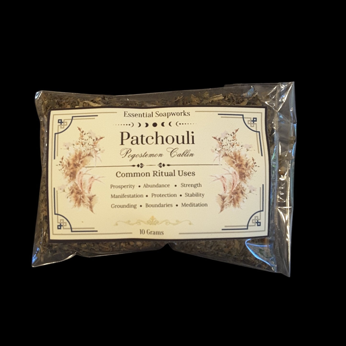 A 10g packet of Patchouli containing dried patchouli leaves, sealed in a clear plastic bag with a cream-colored label, shown against a solid black background.
