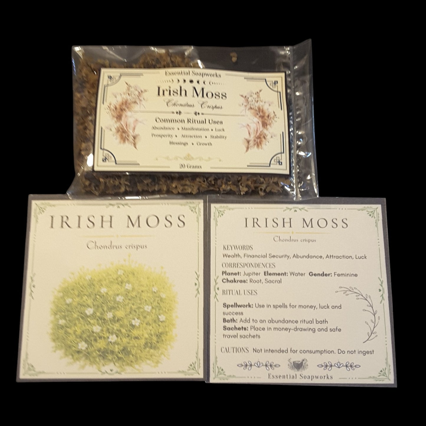 Two product cards and a clear plastic bag containing dried botanicals for Irish Moss, shown on a black background. The cards display floral illustrations and text detailing the product's key words, correspondences, and spiritual uses.