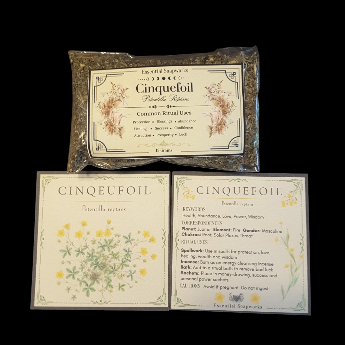 Three items from Essential Soapworks' Cinquefoil set arranged on a black background: a sealed bag of dried botanicals, a printed card with yellow floral illustration, and another printed card with text details.