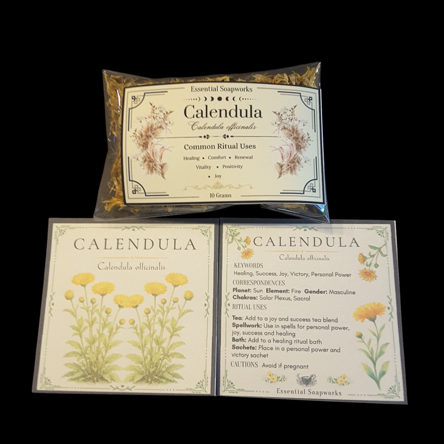A package of Calendula flowers on a black background with two printed cards below with floral illustrations and text for Calendula.