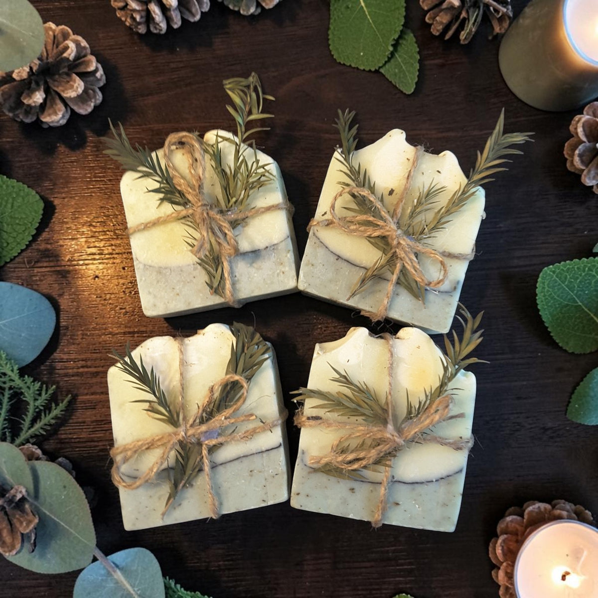 eucalyptus mint christmas botanical soap on a dark wooden surface with pine cones and holly and candles