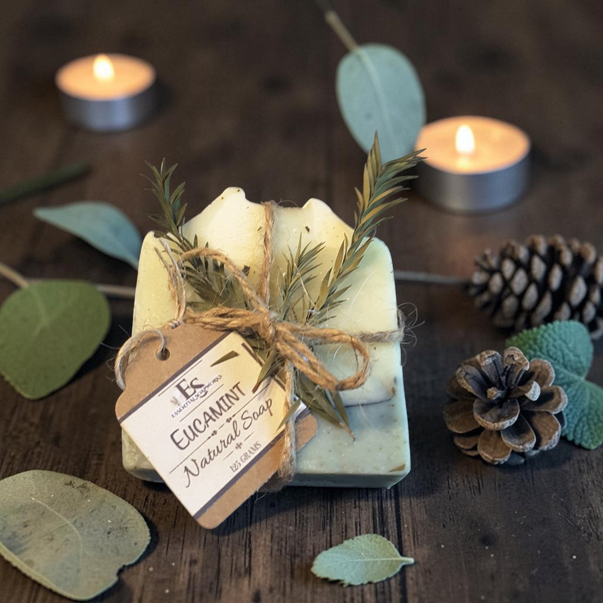 eucalyptus mint christmas botanical soap on a dark wooden surface with pine cones and holly