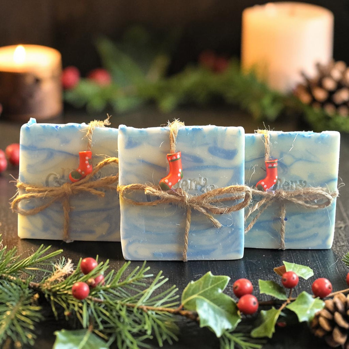 snowdrift christmas soap on a wooden surface with pine cones and pine needles with a candle in the background