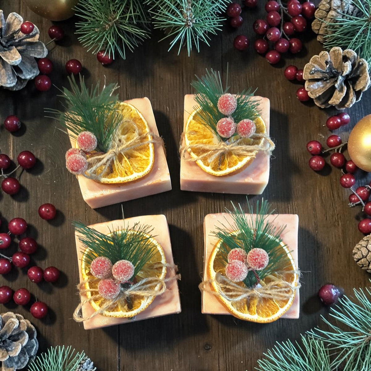 cranberry orange christmas soap on a wooden surface with pine needles and cranberries