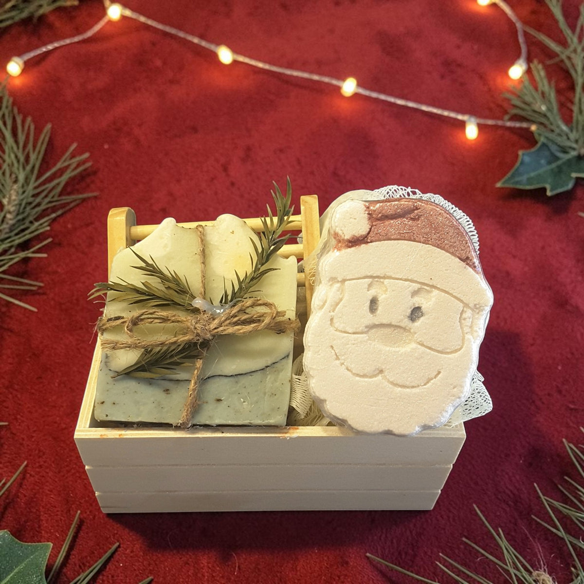 eucalyptus mint christmas gift crate spa kit featuring eucalyptus mint soap, santa shaped bath bomb, bamboo soap ladder and loofah in a wooden crate on a red fabric surface 