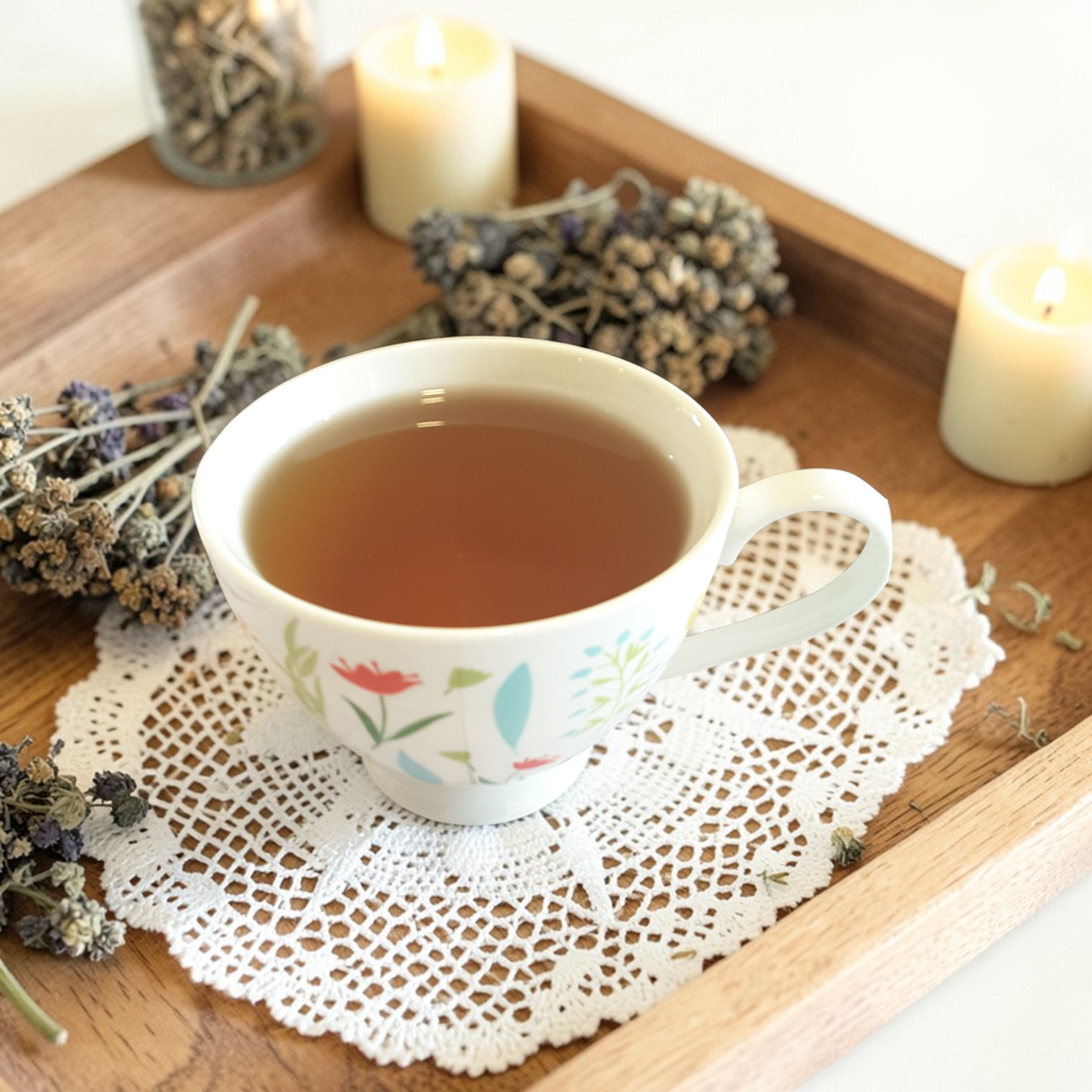 Worthy & Whole Emotional Wellness Tea on a doily with candles and dried herbs on a wooden tray