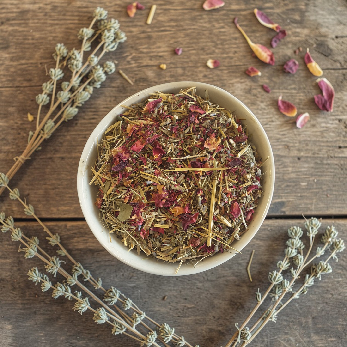 Evening wind down tea in a bowl on a wooden surface with dried herbs and flowers.