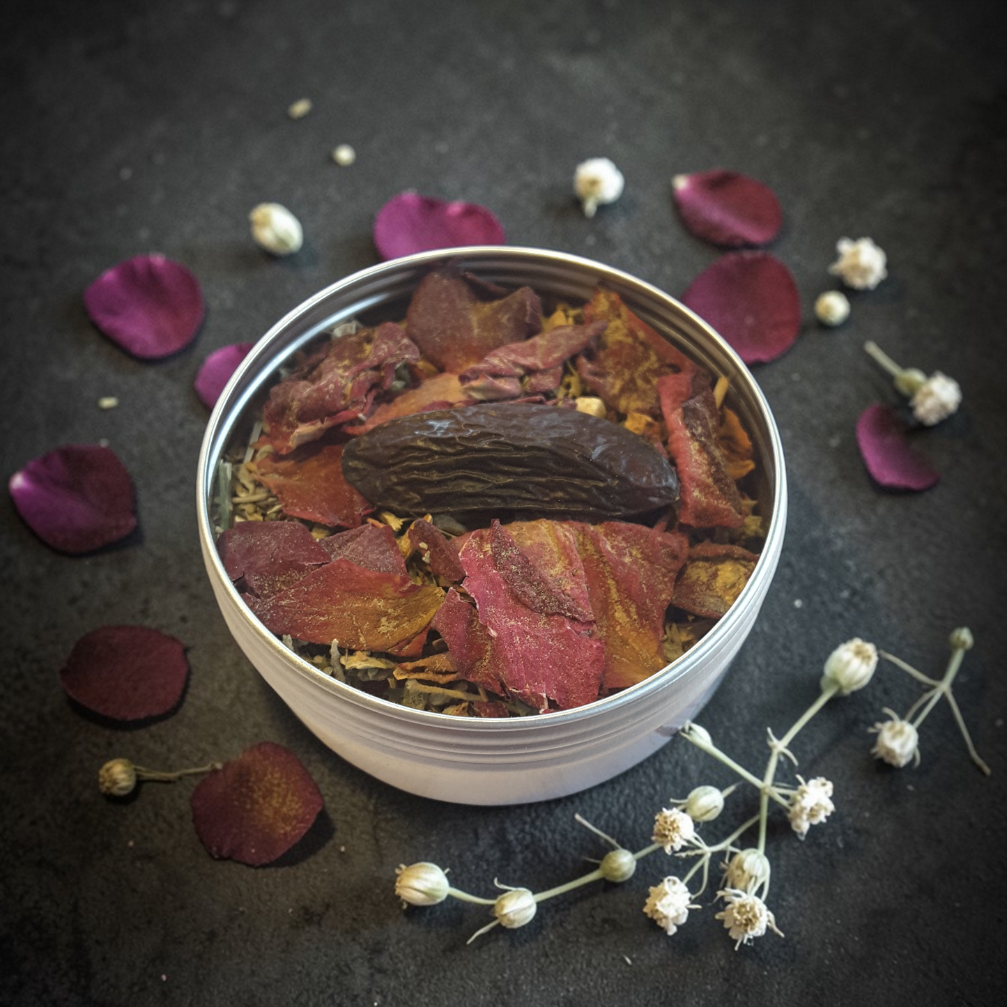 Love Spell loose incense on a dark surface with petals and flowers around