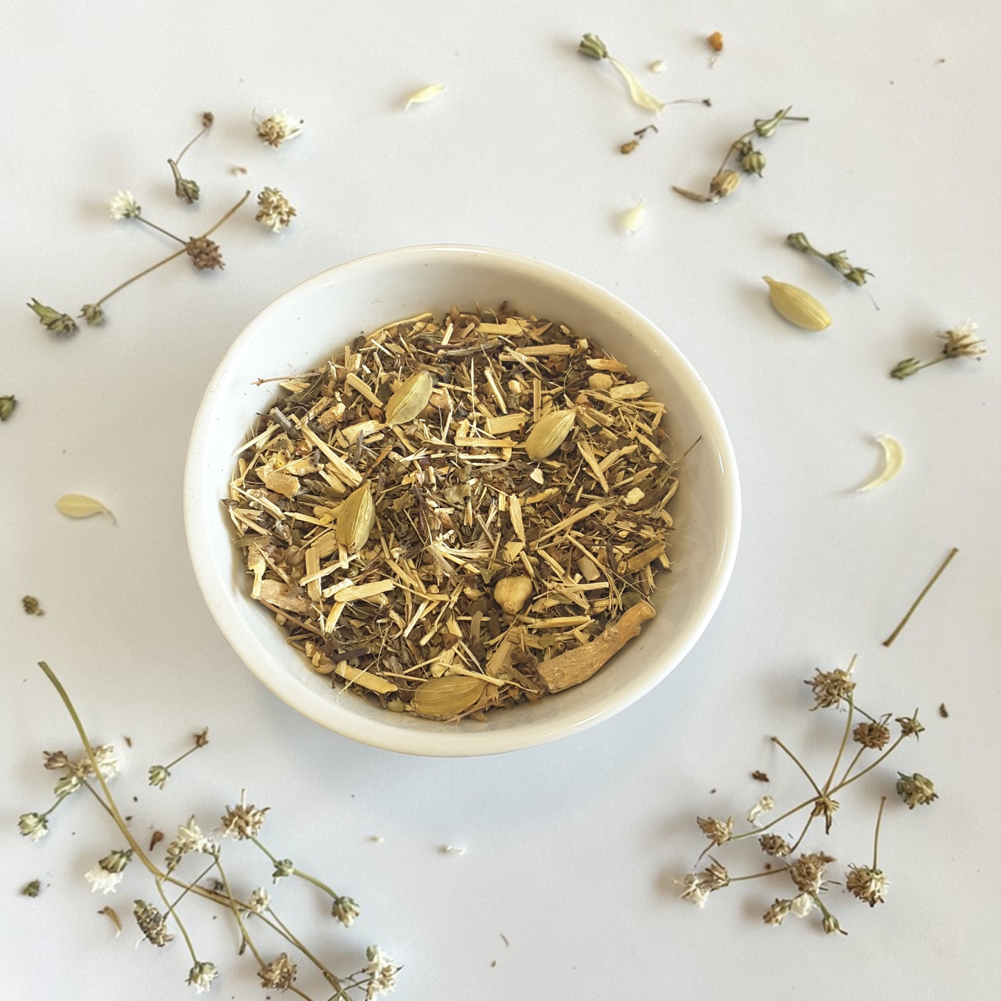 Courage emotional wellness tea blend on a light background with scattered herbs.