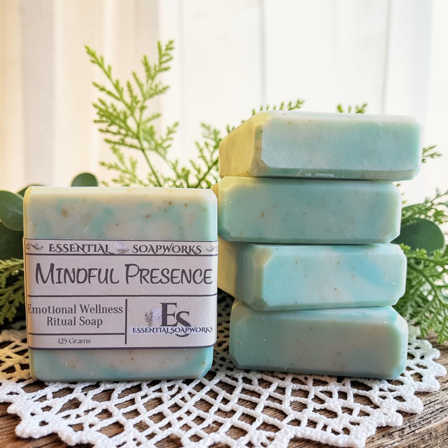 Mindful Presence Emotional Wellness Soap on a doily with plants in the background.