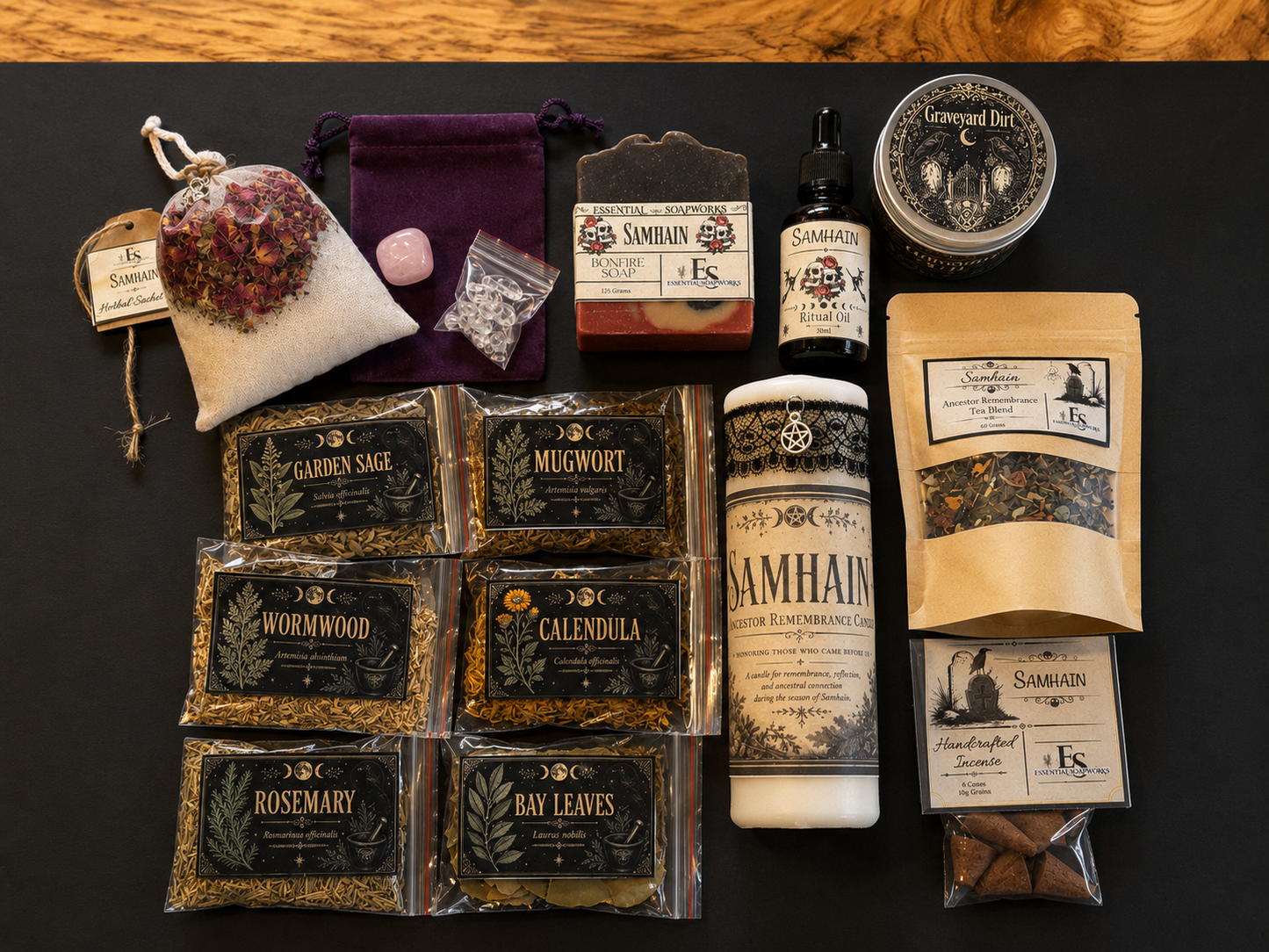 A flat-lay arrangement of a Samhain ritual kit  on a black surface, including a white sachet with dried flowers, a purple velvet bag, a soap bar, a small bottle, a round tin, a jar of ritual oil, a stand-up pouch, and eight individually packaged herbs in clear bags.