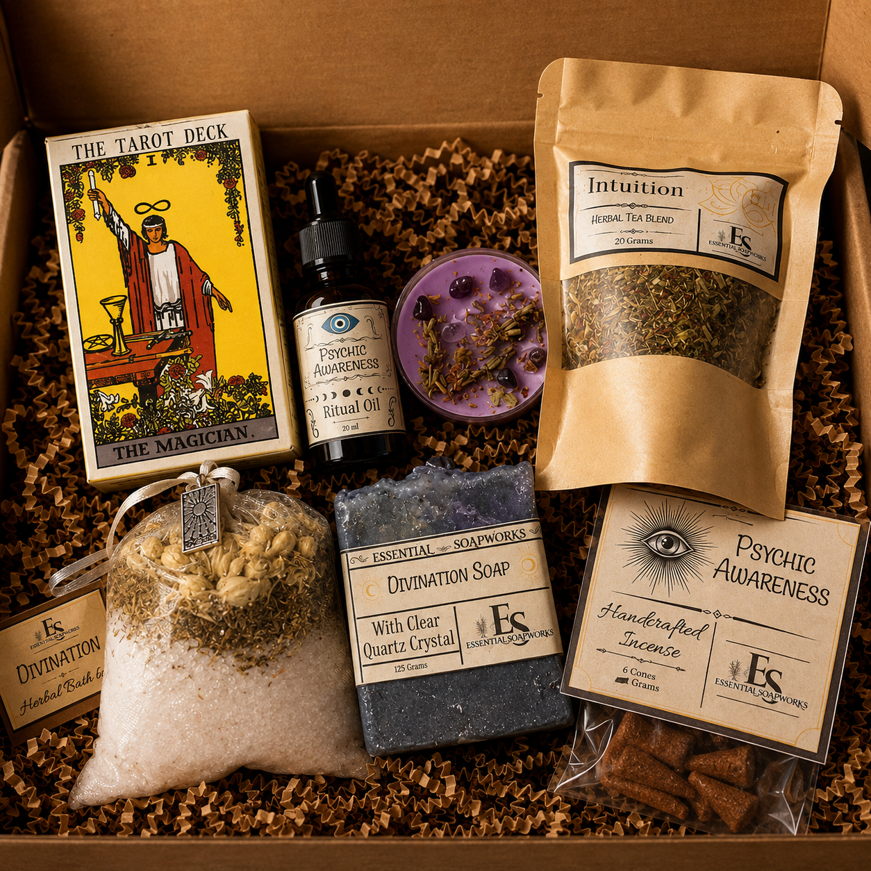 A curated spiritual gift box filled with ES Energy Co. products, including a tarot deck, drivination soap, intuition tea blend, psychic affirmation incense, and a ritual oil, arranged in brown crinkle paper inside a cardboard box.