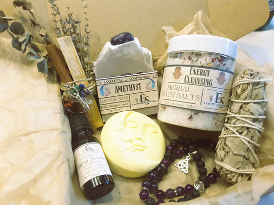 Collection of wellness and self-care items including a bottle, soap, and salt on a textured surface.