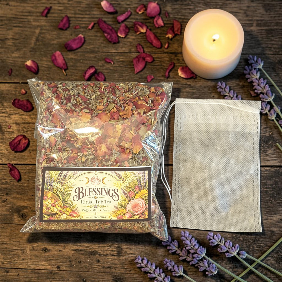 blessings tub tea next to a muslin bag on a dark wooden surface with rose petals, lavender and candles