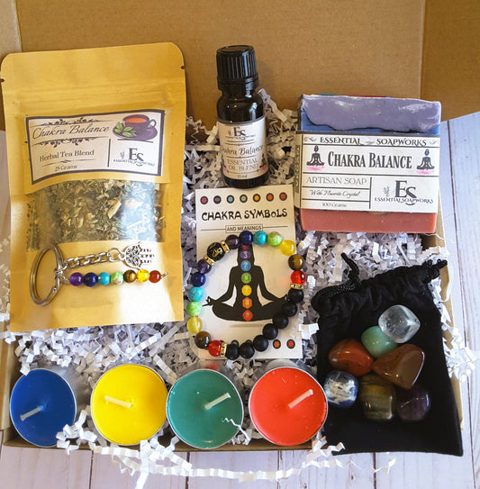 chakra balance kit with soap, tea, essential oil, crystals, candles and bracelet on a white background