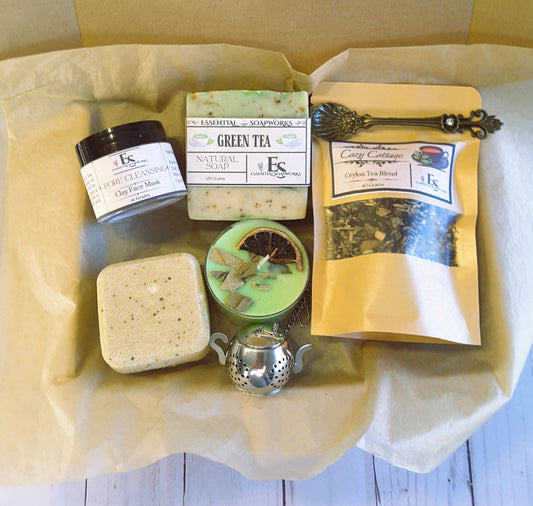 Collection of natural products including a face mask, soap, tea, and bath items on a wooden surface.