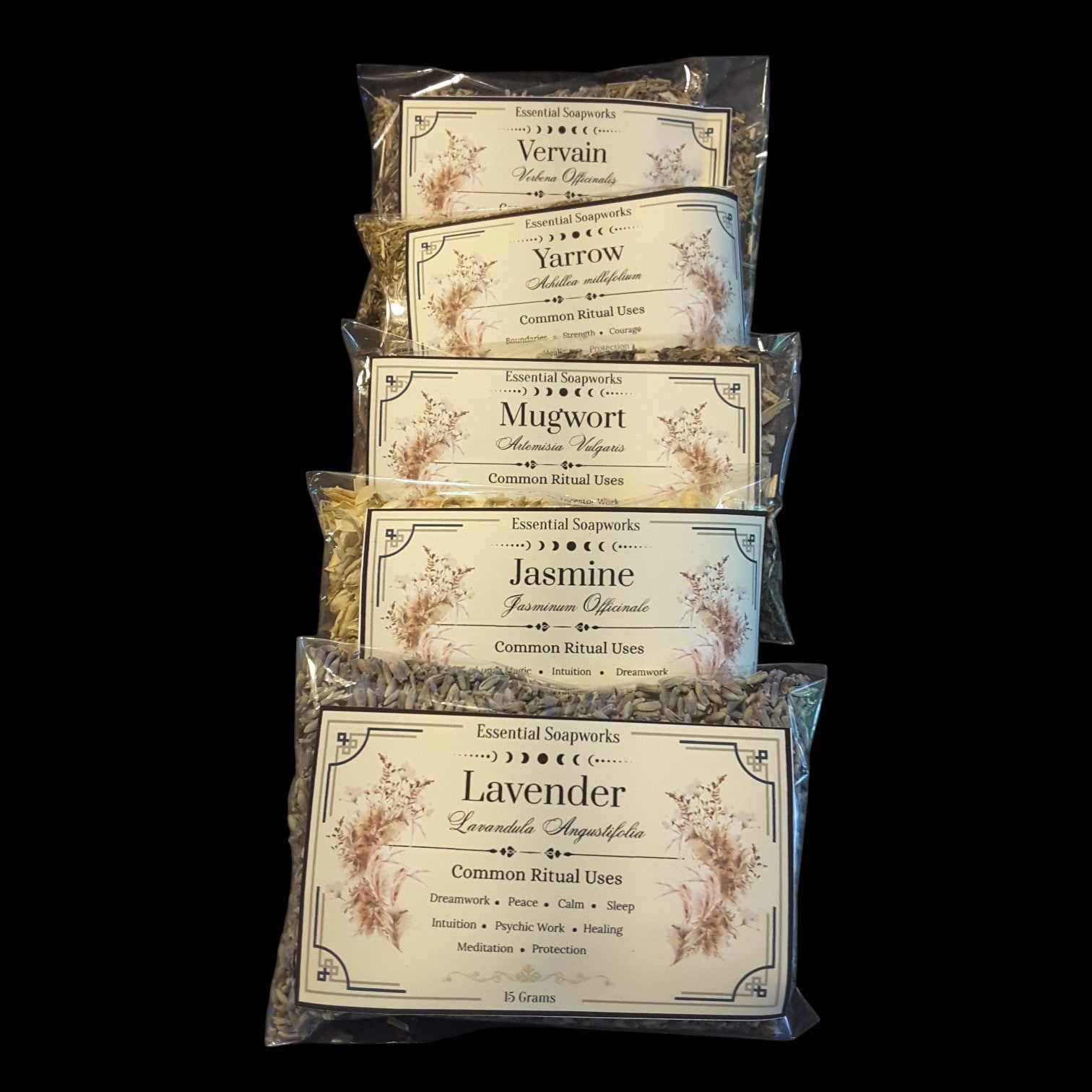 Five clear plastic bags of witchy herbs for divination stacked vertically on a black background. The bags contain lavender, mugwort, yarrow, and vervain with labels for Lavender, Jasmine, Yarrow, and Vervain visible.