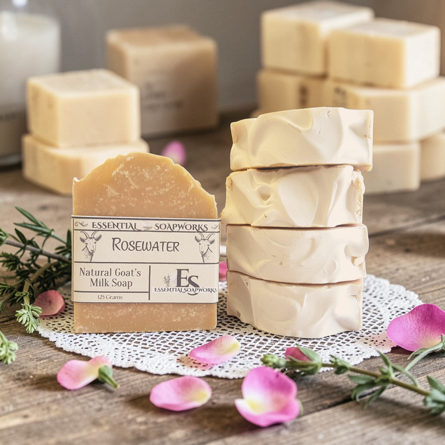 Stack of natural goat milk soap bars on a wooden surface with pink flowers.