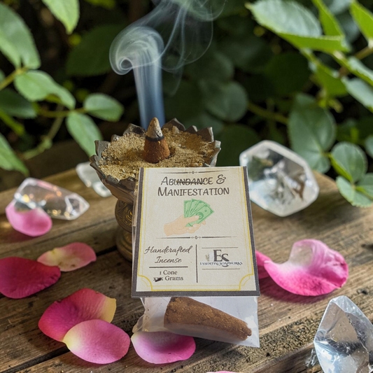 Incense cone with 'Abundance & Manifestation' label on a wooden surface with pink petals and crystals.