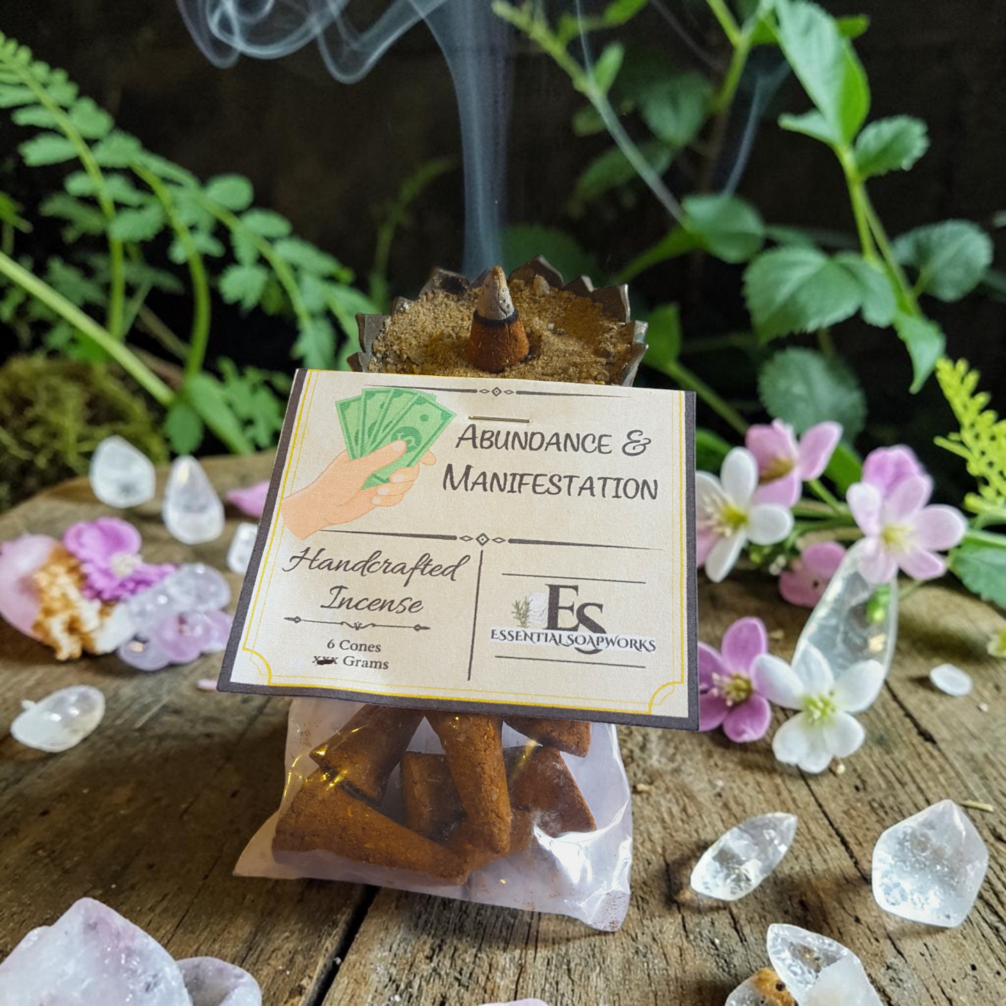 Handcrafted abundance incense on a wooden surface with crystals and flowers.
