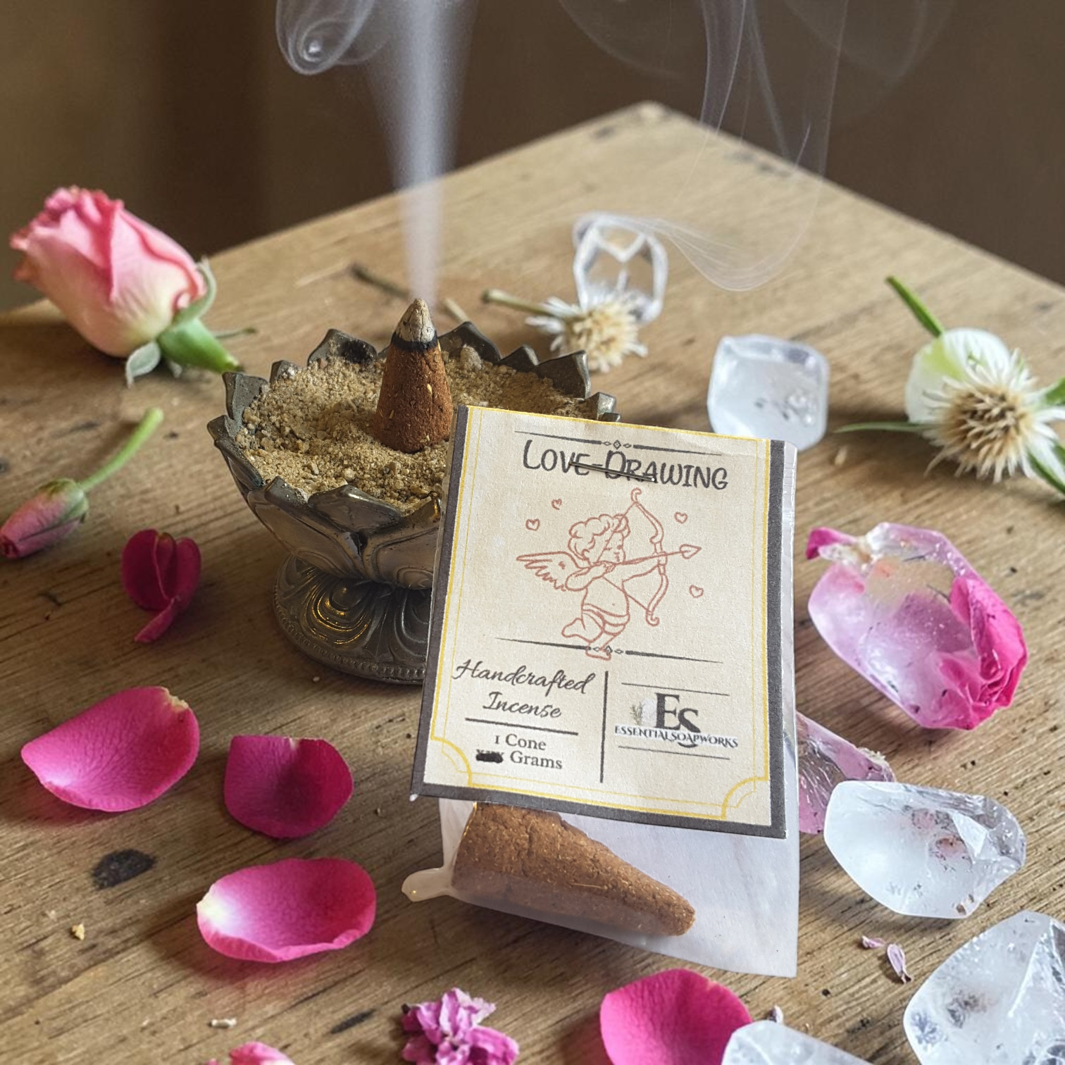 Incense cone with packaging labeled 'Love Drawing' on a wooden surface with flowers and crystals.