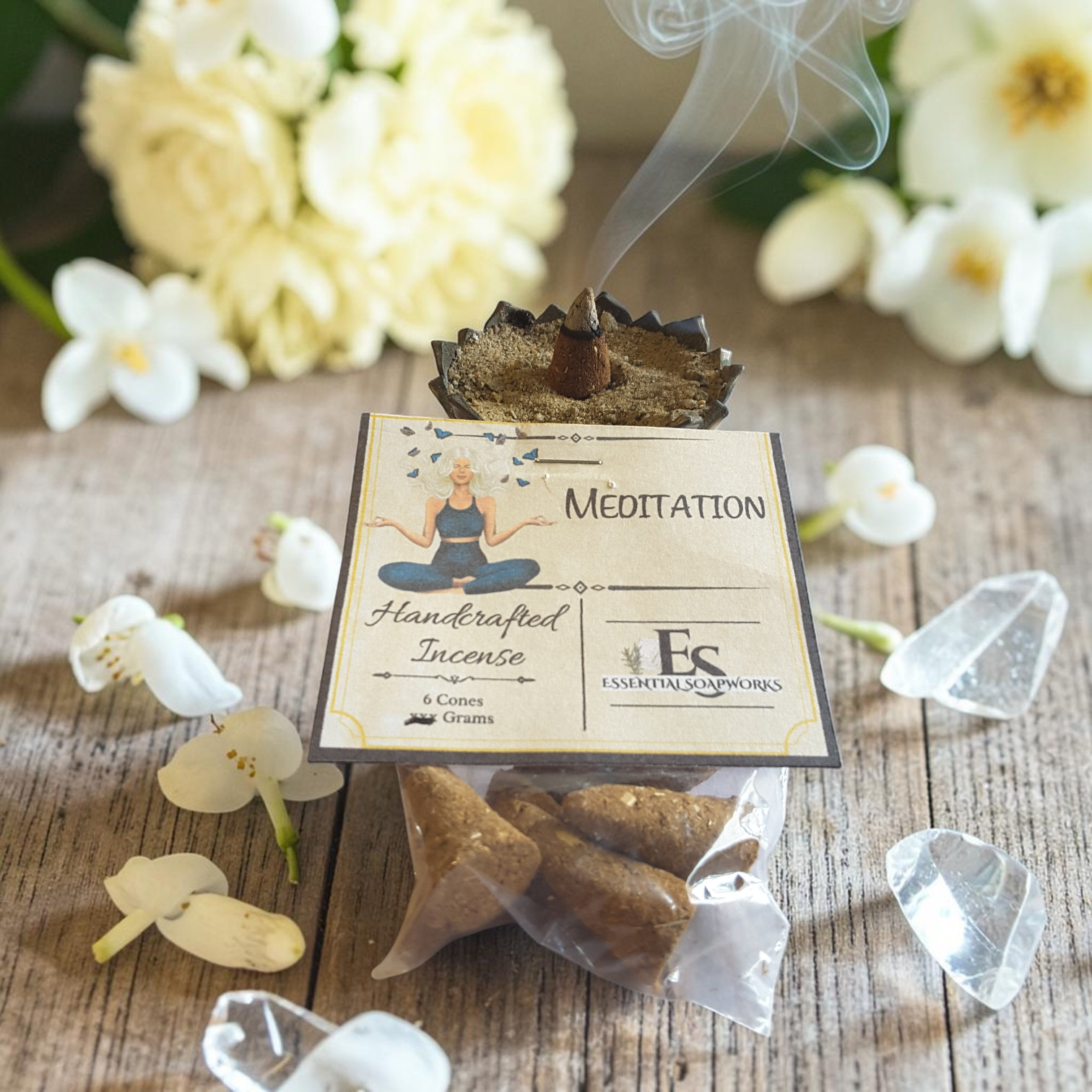 Handcrafted meditation incense on a wooden surface with flowers and crystals.