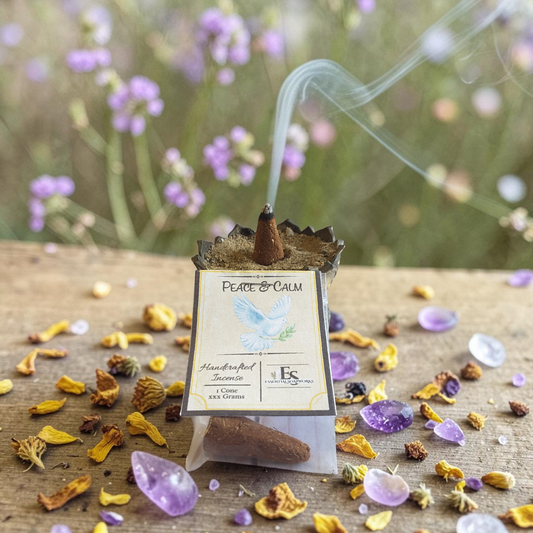 handmade peace and calm incense with smoke, surrounded by dried flowers and crystals on a wooden surface.