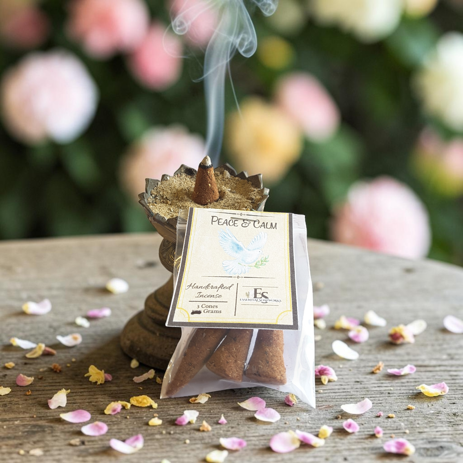 handmade peace and calm incense on a wooden surface with flower petals.