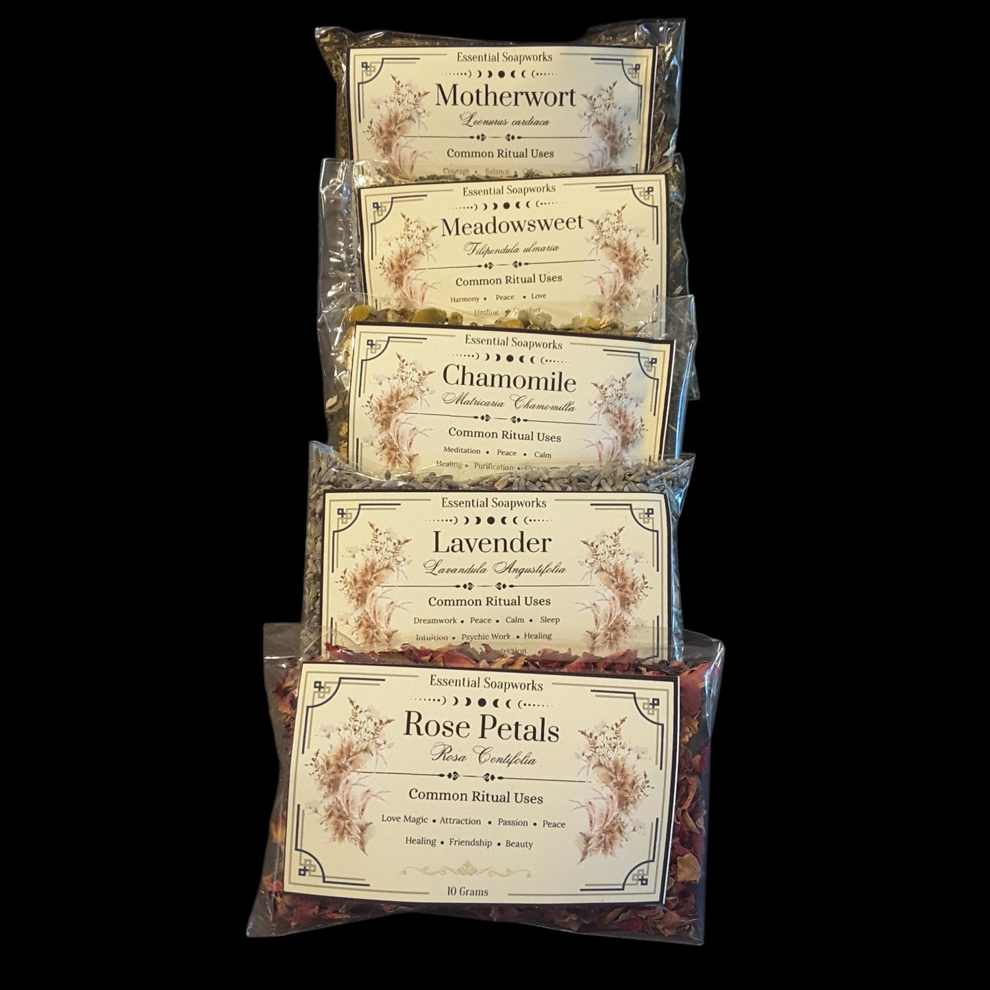 Five clear plastic bags of witchy herbs for peace and tranquility arranged in a vertical stack against a solid black background. The bags feature vintage-style cream labels with floral illustrations and text including 'Motherwort', 'Meadowsweet', 'Chamomile', 'Lavender', and 'Rose Petals'.